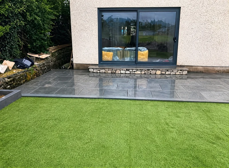 Grey patio beside a green lawn